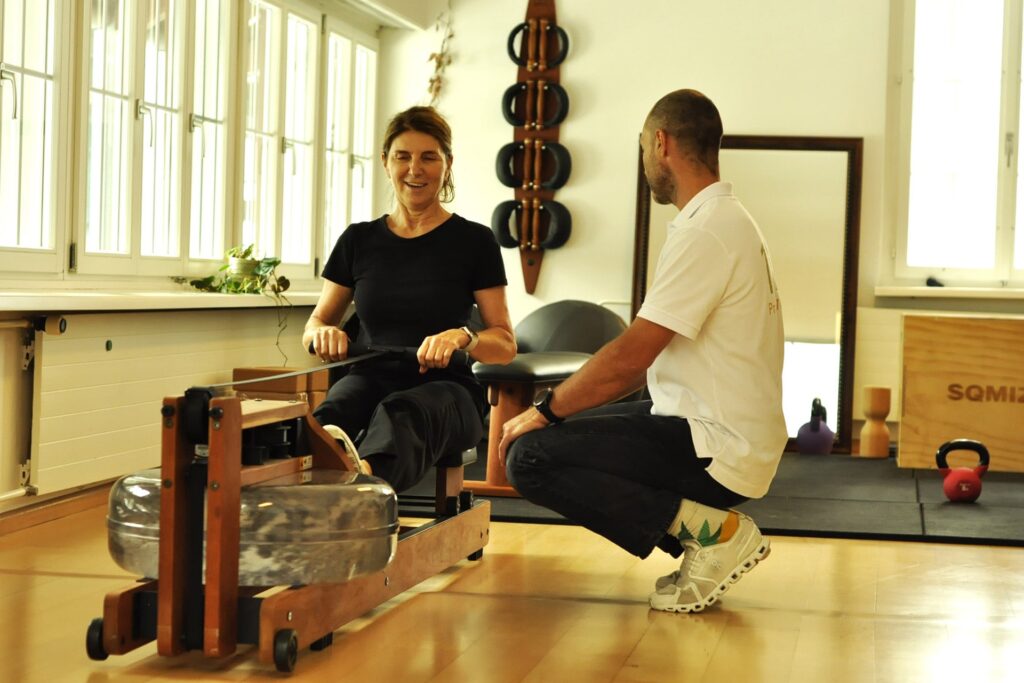 Dieses Foto zeigt eine Patientin der Praxis111 in Basel mit einem Therapeuten an einem Ruderger&auml;t im Rahmen der ger&auml;tegest&uuml;tzten MTT (Medizinischen Trainingstherapie)